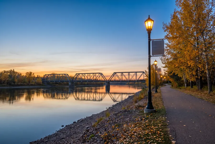 Prairie river at dusk with a steel truss bridge