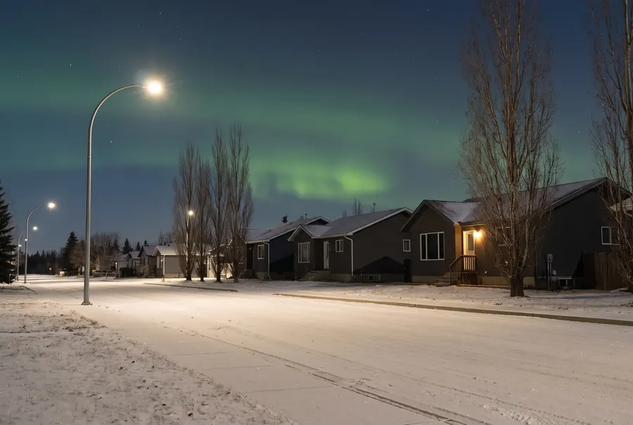 Snowy street under the northern lights before dawn